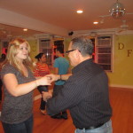 Vallery and Ray dancing salsa in dance studio.